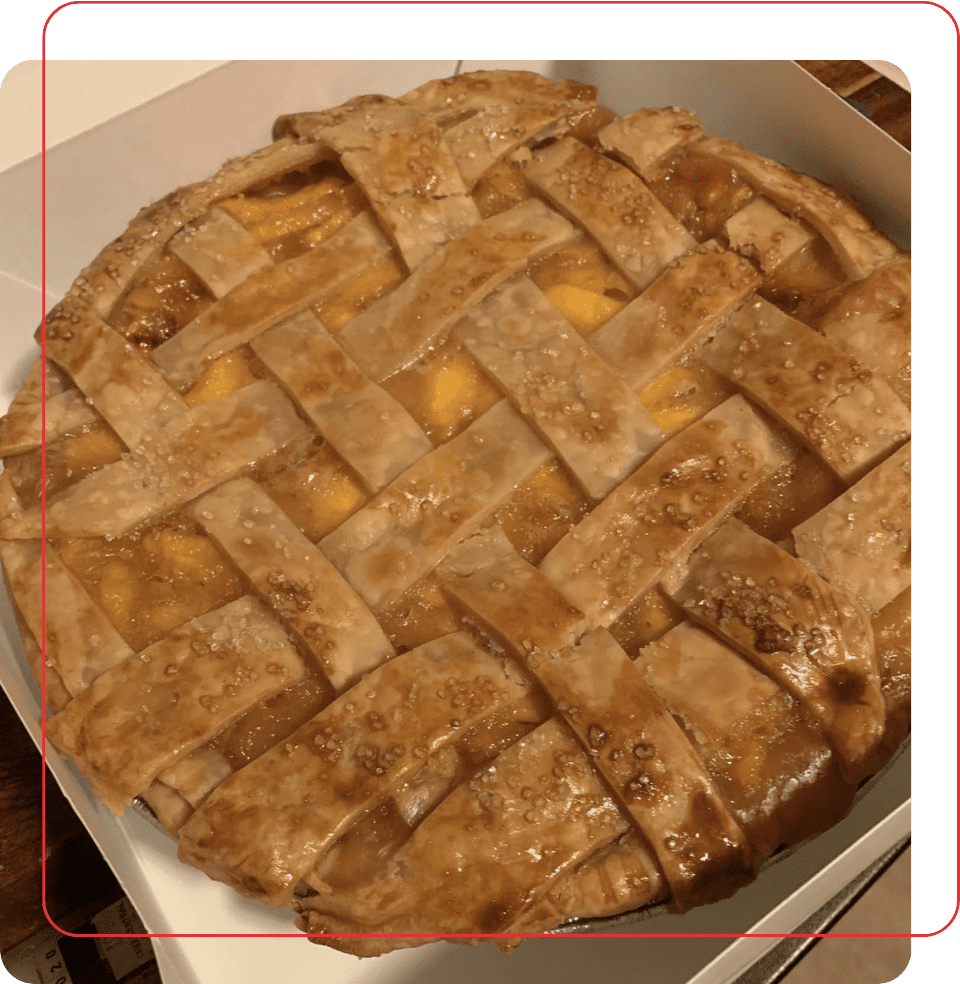 A pie sitting in a box on top of the floor.