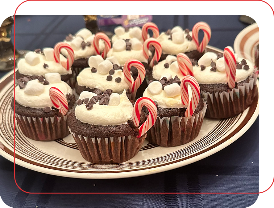 A plate of chocolate cupcakes with white frosting and candy canes.