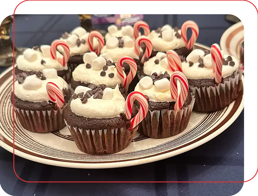 A plate of chocolate cupcakes with white frosting and candy canes.